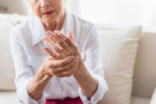 Woman massages hands to relive joint pain.