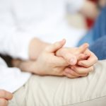 close up of two people holding hands