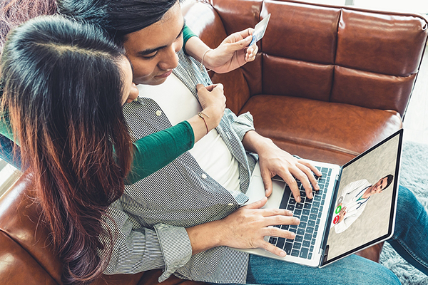 Happy couple at home having a telemedicine visit