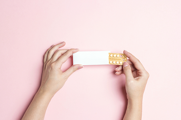 Woman holding pack of birth control