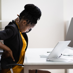 Black woman holding back in pain