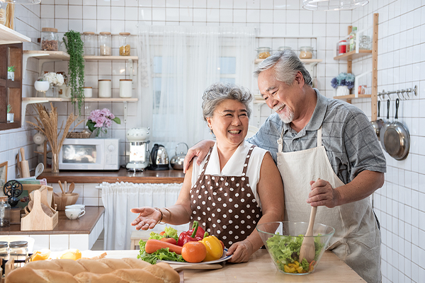 Older Asian couple cooking at home