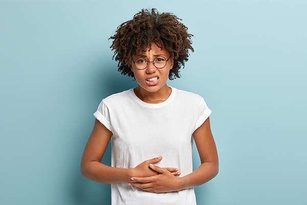 Black woman holding stomach in pain