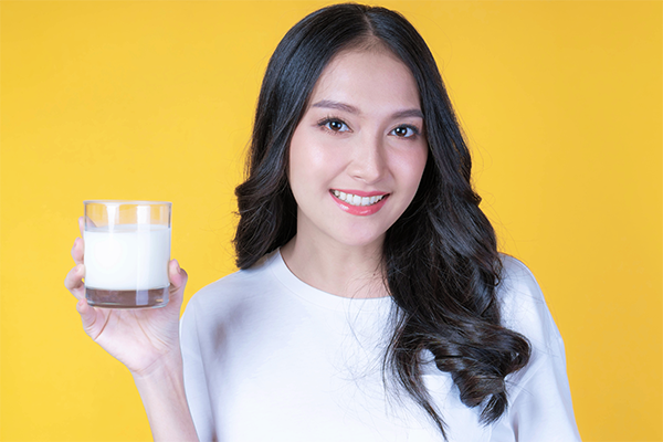 Asian woman holding a glass of milk