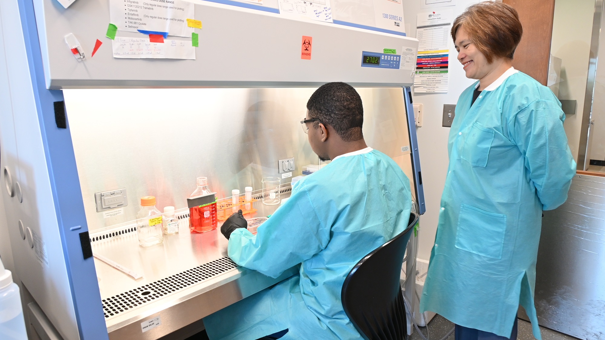 A mentor and mentee practicing how to wash cancer cells for research project