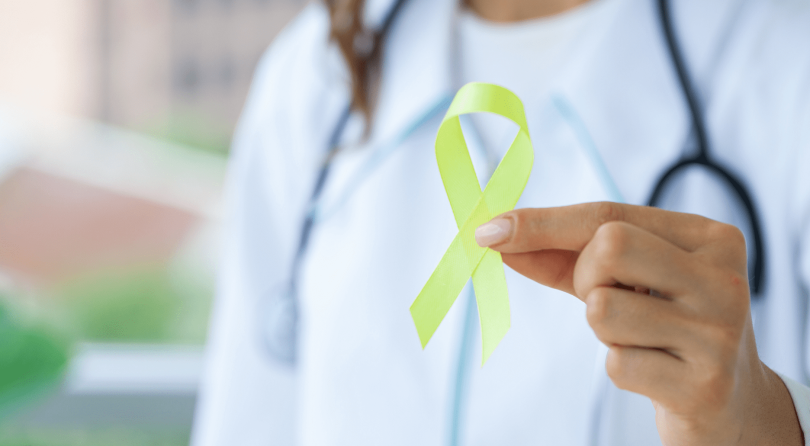 Physician holding a lime green ribbon to bring awareness to different forms of lymphoma diagnosed in cancer patients.