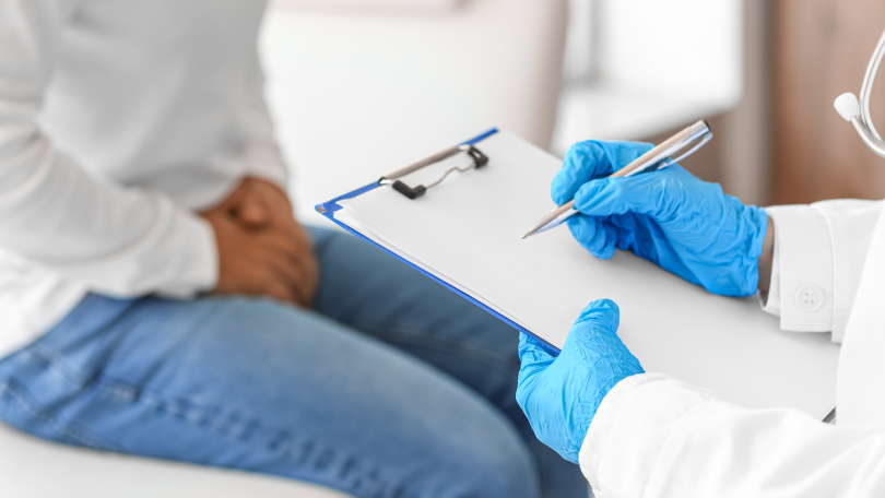 A doctor takes down notes during a visit with a man who may be living with prostate cancer.