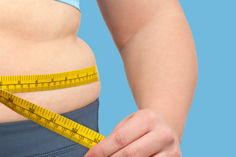 Woman measuring her waistline while deciding whether to have surgery to help her loose weight.