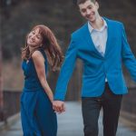 A man wearing a blue sport coat is hoding the hand of a woman wearing a blue dress. Blue is the color of the ribbon signaling Prostate Cancer Awareness Month.