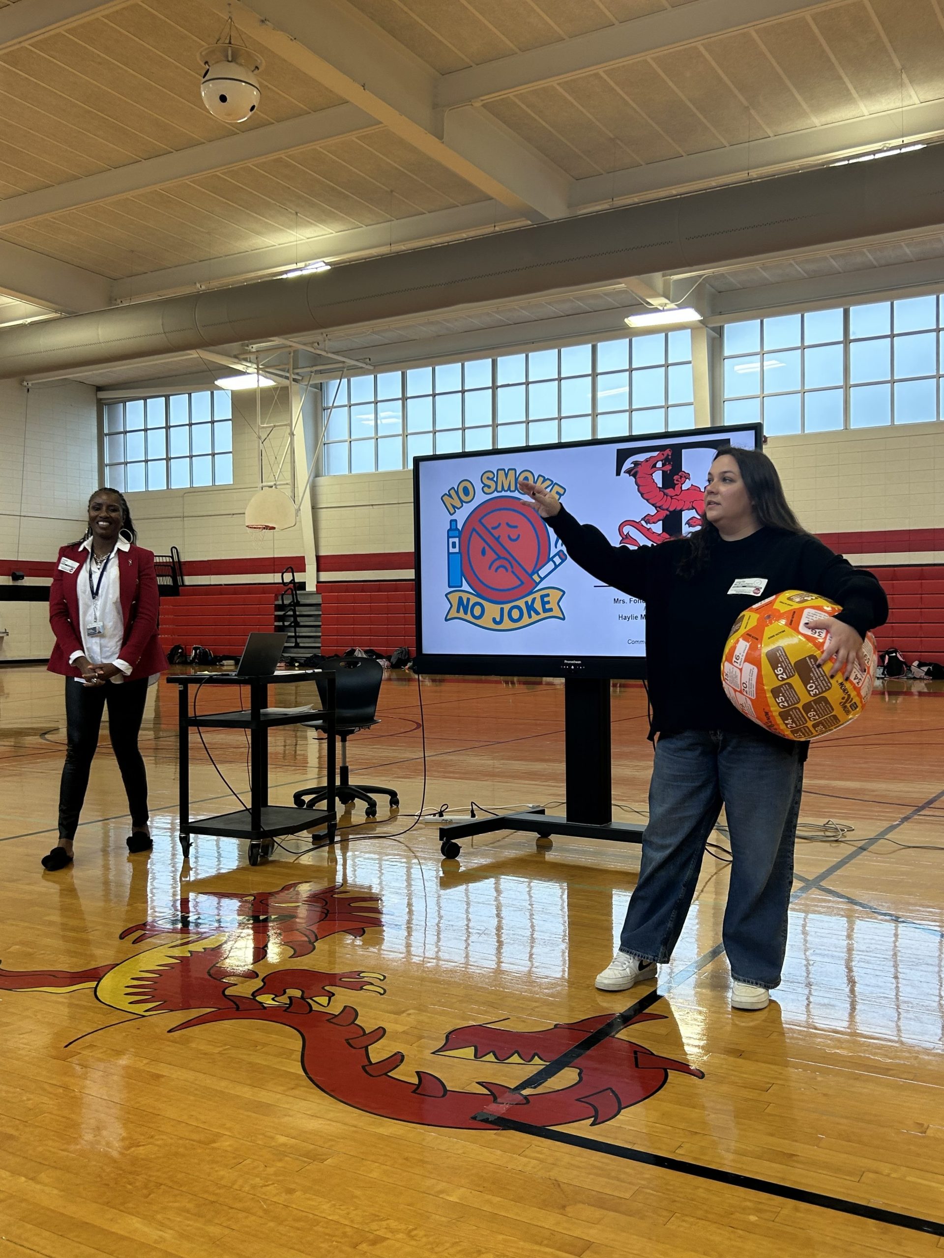 two woman standing in front of a tv